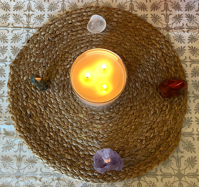 Candle and crystals: labradorite, clear quartz, carnelian, and amethyst.